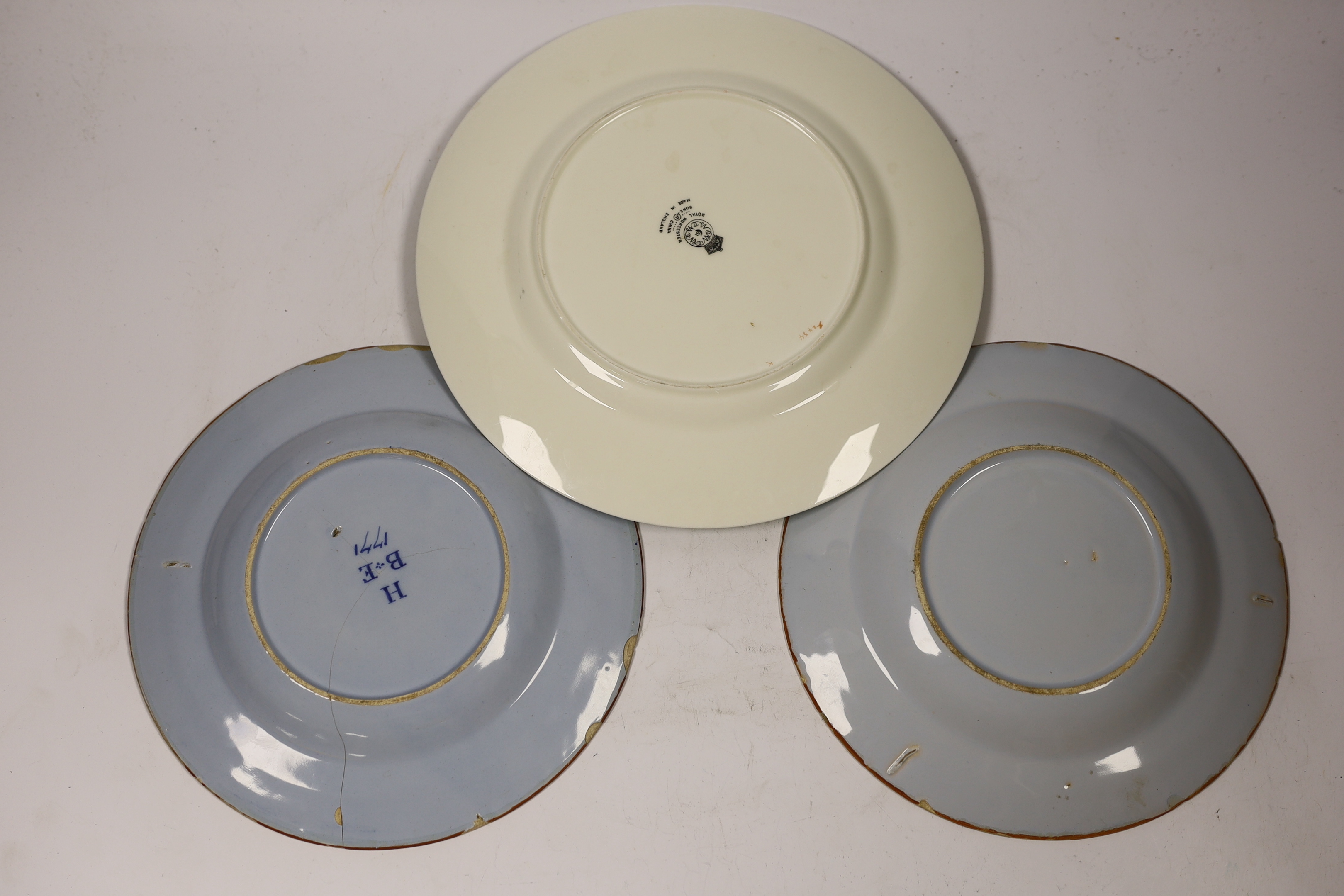 A pair of Delft plates, one dated 1771 and another Royal Worcester floral decorated plate, 27cm diameter